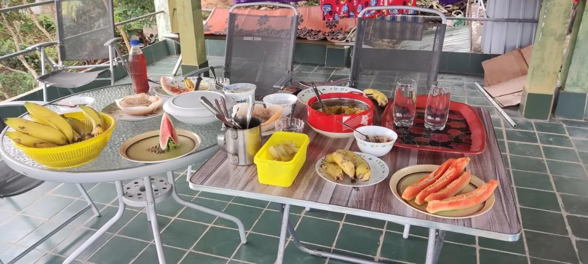 Breakfast of hoppers, fruit and curries laid out on the rooftop table