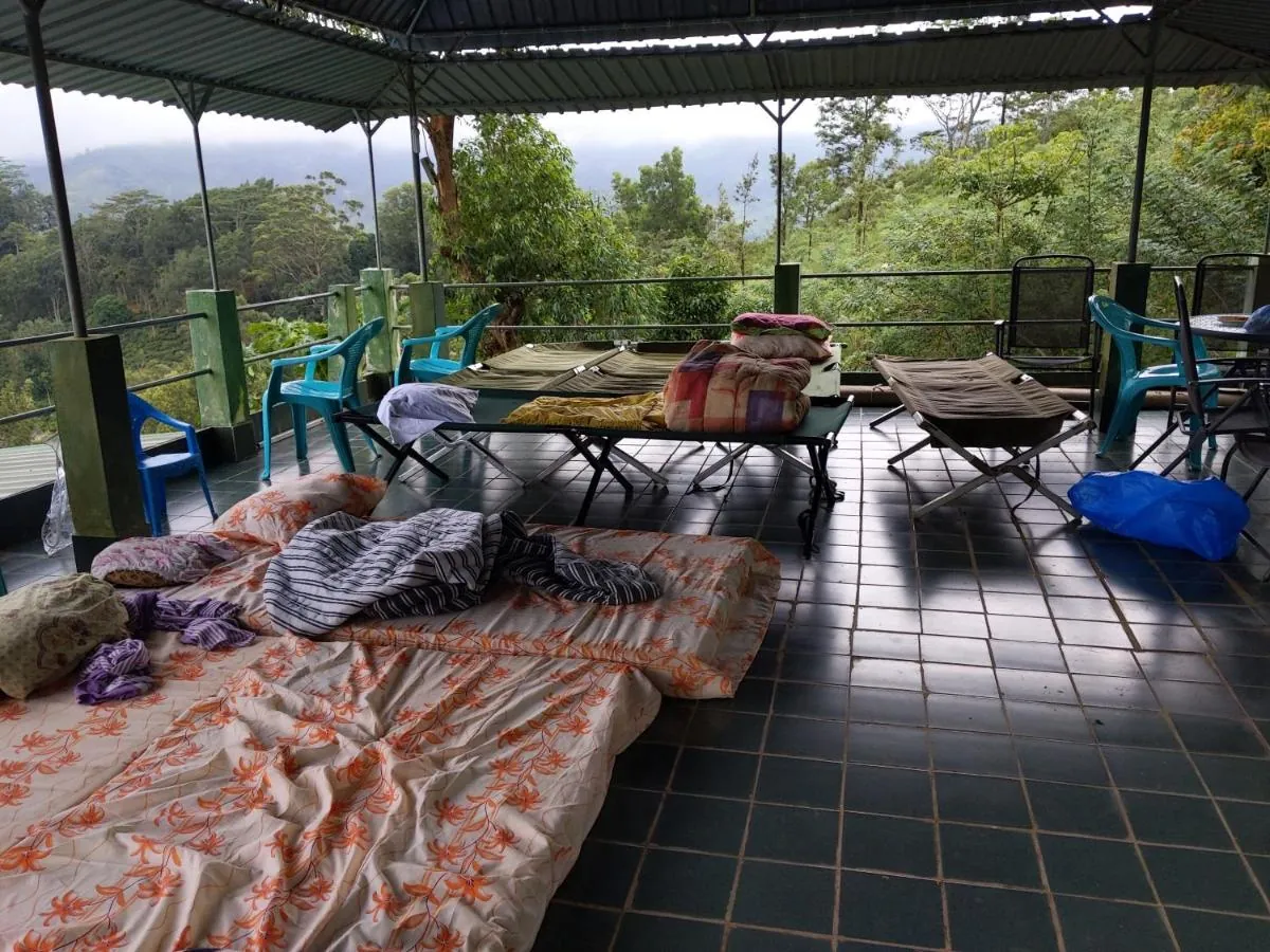 Sleeping mats laid out under the roof of the open hut with the hills beyond