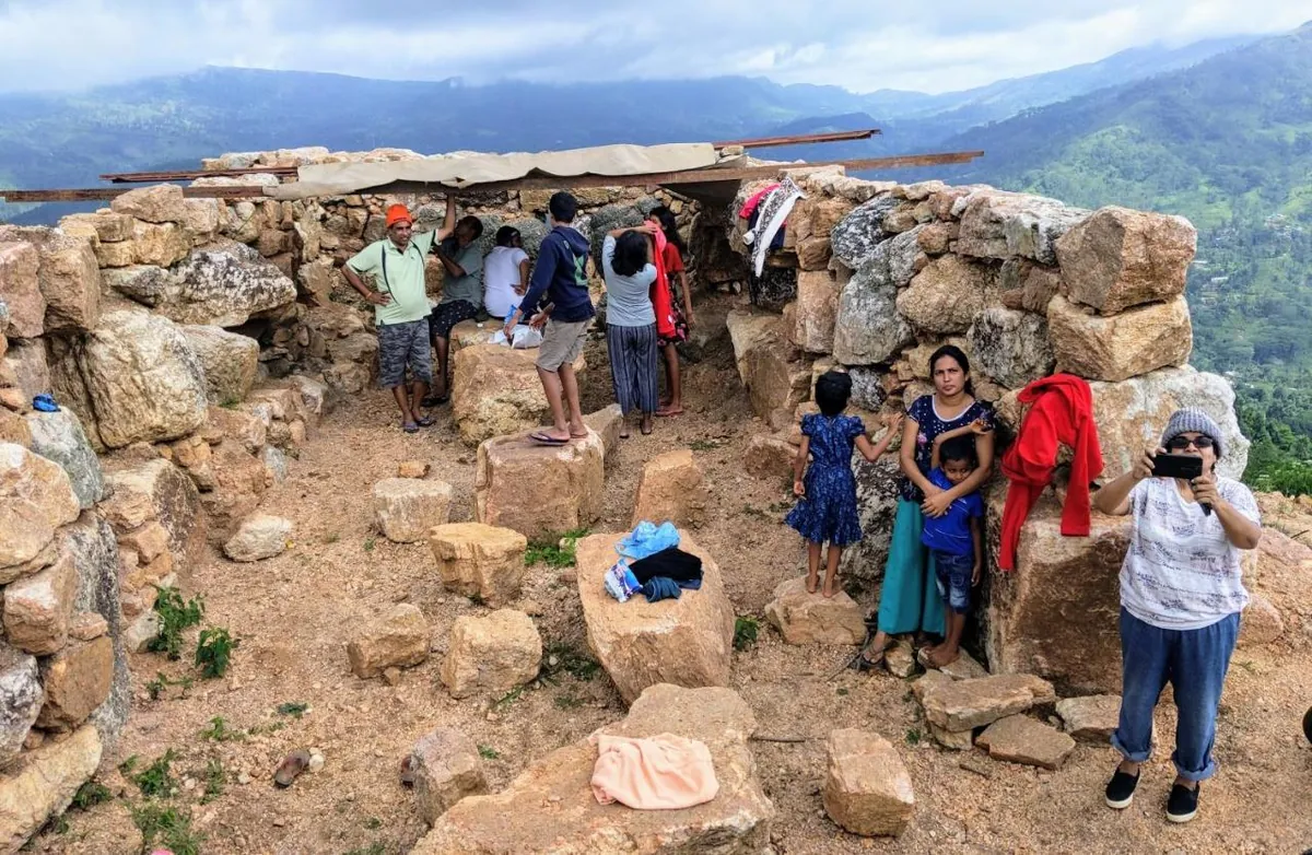 Hikers resting among the stone ruins on the peak
